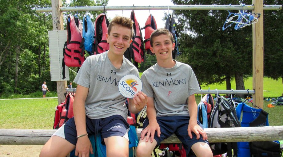 Two boys holding a SCOPE support sticker
