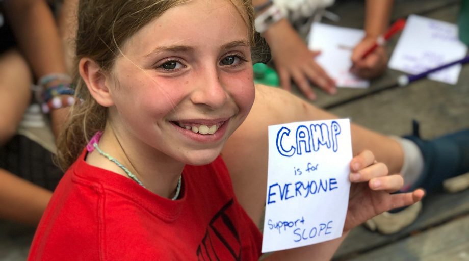 girl holding "Camp is for Everyone" note