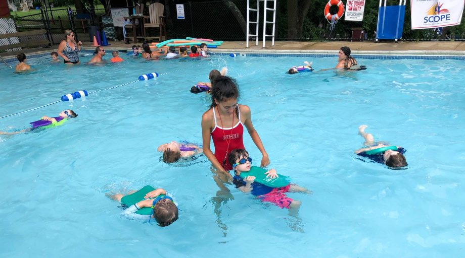 swim instructor teaching kids how to swim