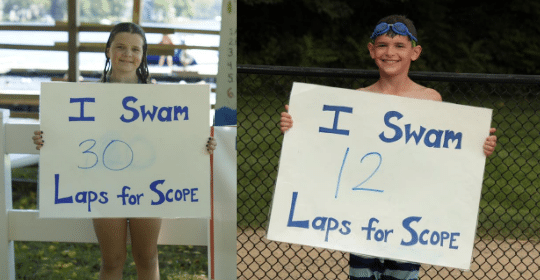 kids holding signs for the number of laps they swam